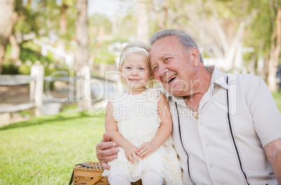 Grandfather and Granddaughter Hugging Outside At The Park