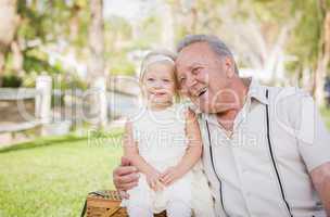 Grandfather and Granddaughter Hugging Outside At The Park