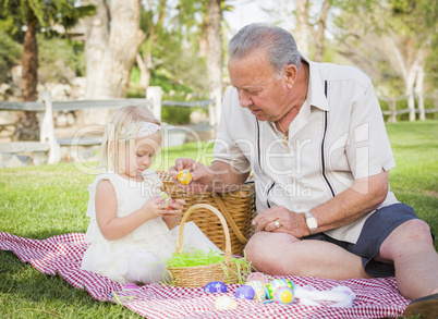 Grandfather and Granddaughter Enjoying Easter Eggs on Blanket At