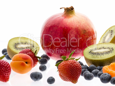 Halved Kiwi Fruits And Berries On White Background