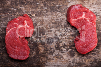 zwei rohen Steaks auf ein Holzbrett