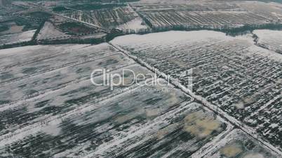 Flying Over Winter Agricultural Fields in Cloudy Weather, aerial view