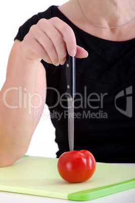 Woman with knife cut the tomato