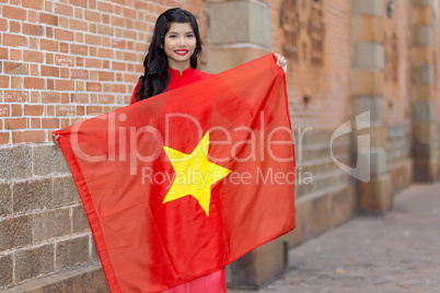 Pretty young Vietnamese woman holding a flag