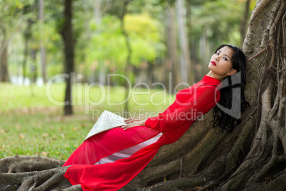 Pretty Vietnamese lady relaxing on tree roots