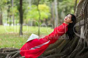 Pretty Vietnamese lady relaxing on tree roots
