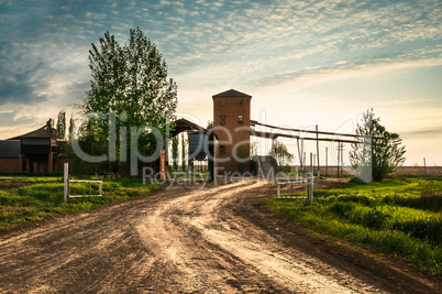 Sun and clouds over field with road. Fantastic landscape