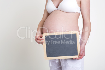 Pregnant woman with an empty blackboard