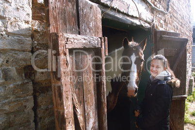 Teenage girl with her beautiful horse friend