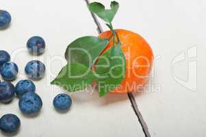 tangerine and blueberry on white table