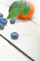 tangerine and blueberry on white table