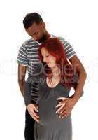 Man standing behind pregnant wife.