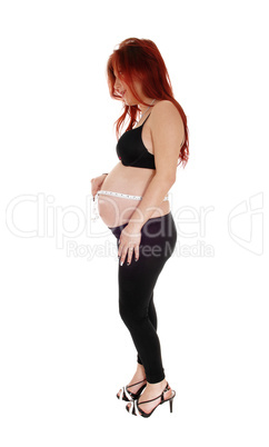 Pregnant woman measuring belly.