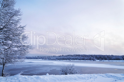 Winter landscape with lake and trees covered with frost