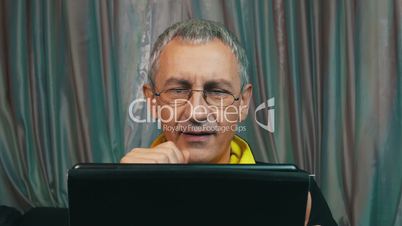Portrait Smiling Man in Glasses Reading a Tablet Computer, closeup