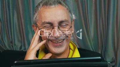 Portrait Laughing Man in Glasses Reading a Tablet Computer, closeup