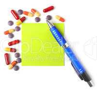 Medications, pen and paper for a prescription.