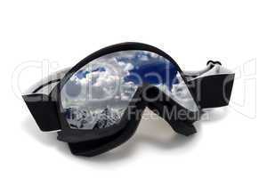 Ski goggles with reflection of cloudy mountains