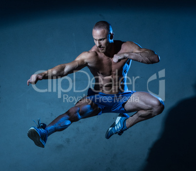 Sporty Young Man in Flying Martial Arts Pose