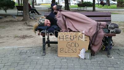 Homeless woman resting on a park bench