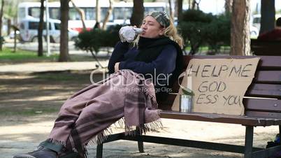 Homeless alcoholic woman drinking wine and coughing