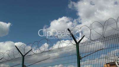 Secured area with a tower, a fence and barbed wire