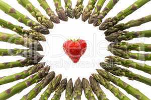 Circle Of Asparagus Tips Pointing At Strawberry.