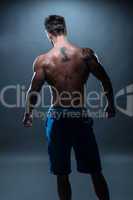Back View of a Topless Athletic Man with Tattoo