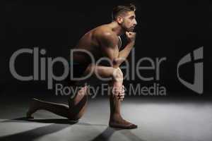 Topless Muscular Man Sitting in a Yoga Position