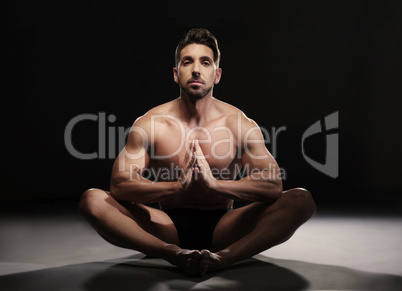 Topless Muscular Man Sitting in a Yoga Position