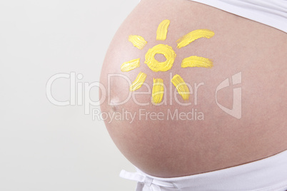 Pregnant woman with yellow sun painted on her belly