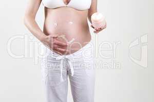 Pregnant woman putting smiley with creme on her belly