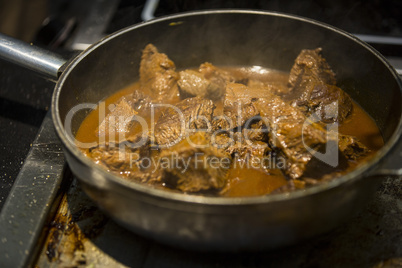 Bratpfanne mit Fleisch auf Herdplatte