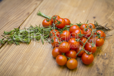 Tomaten/Strauchtomaten und Rosmarin auf Tischplatte