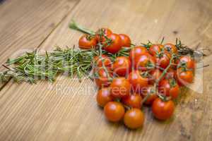 Tomaten/Strauchtomaten und Rosmarin auf Tischplatte