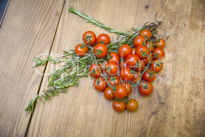 Tomaten/Strauchtomaten und Rosmarin auf Tischplatte