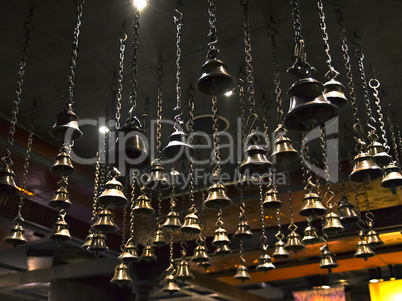 many ritual bells hanging on chains from the ceiling
