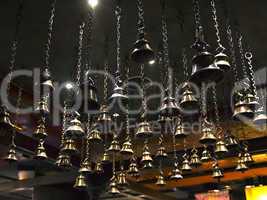 many ritual bells hanging on chains from the ceiling