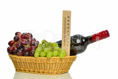 Rotwein mit Weintrauben im Korb
