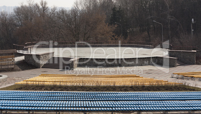 Row of wooden seats on a spectator grandstand photo. Bench in the park for the show