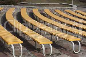 Row of yellow wooden seats on a spectator grandstand photo