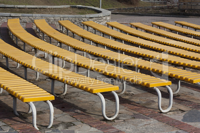 Row of yellow wooden seats on a spectator grandstand photo