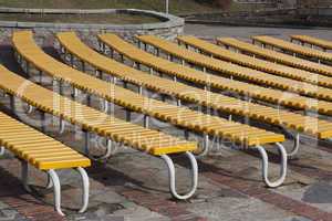 Row of yellow wooden seats on a spectator grandstand photo