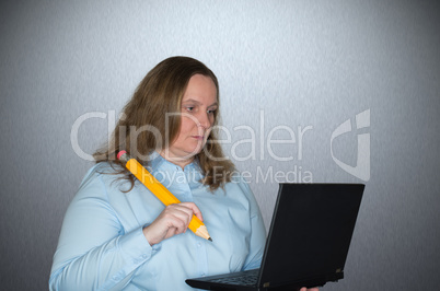 Frau mit Notebook und Stift am Arbeiten