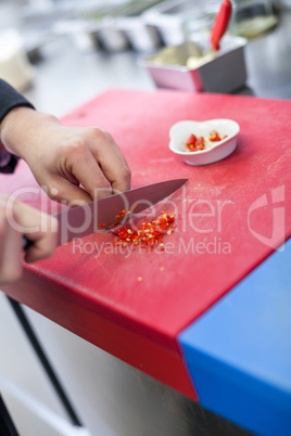 Chef dicing red hot chili peppers