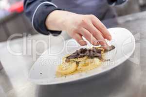 Chef grating truffle mushroom onto ravioli pasta