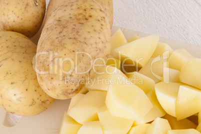 Whole Potatoes and Chopped Pieces on Cutting Board