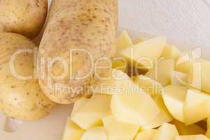 Whole Potatoes and Chopped Pieces on Cutting Board