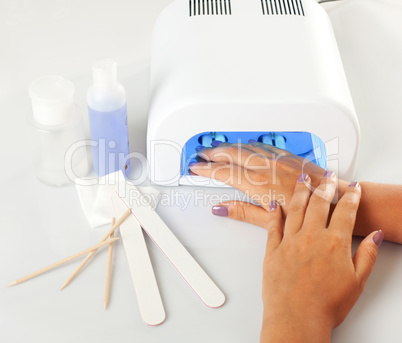 Hands with uv lamp for nails