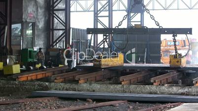 Workers transfer steel blocks